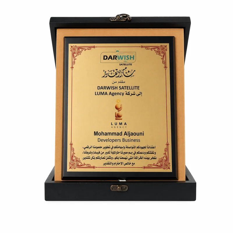 Gold plaque with an ornamental red border in a black presentation box, presented by Darwish Satellite to LUMA Agency.